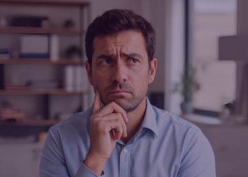 Homem com expressão de dúvida sentado em escritório, simbolizando incertezas sobre controle de jornada e exceções de ponto eletrônico.